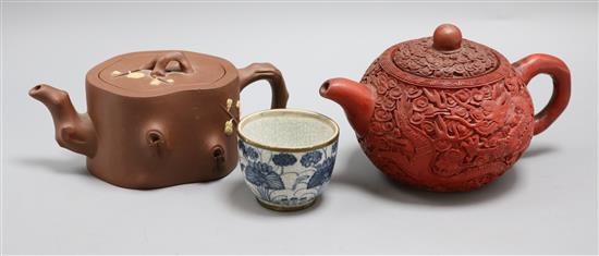 Two Yixing teapots, one with carved cinnabar lacquer decoration and a tea bowl